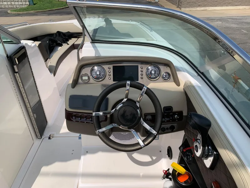 Slide: The Image of 2014 Regal 27 FasDeck boat cockpit with steering wheel and dashboard controls. - 7