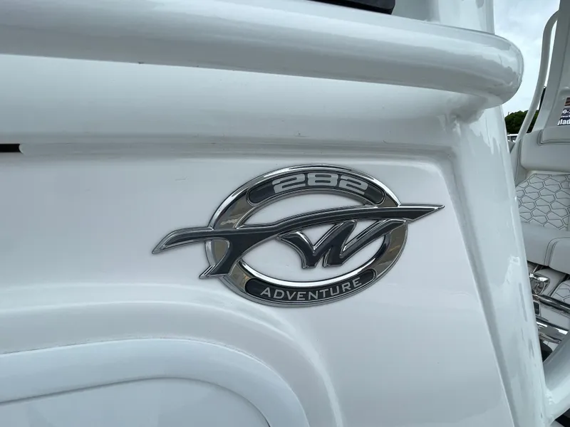 Slide: The Image of 2026 Tidewater 282 CC Adventure boat emblem on white surface. - 10