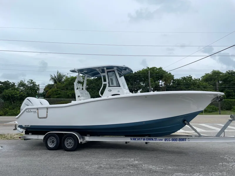 Slide: The Image of 2026 Tidewater 282 CC Adventure boat on trailer, parked outdoors. - 2