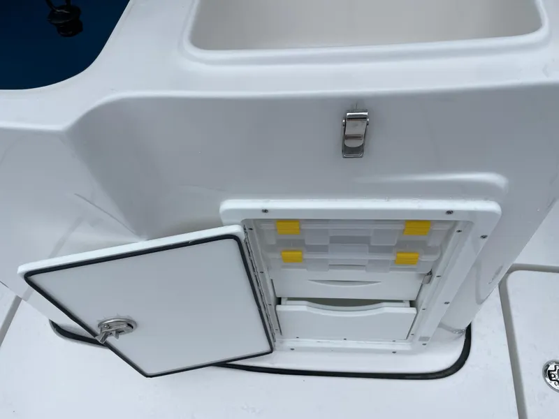 Slide: The Image of 2026 Tidewater 282 CC Adventure boat storage compartment with open hatch and latch. - 21