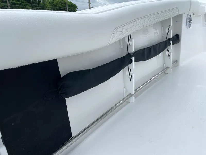 Slide: The Image of 2026 Tidewater 282 CC Adventure boat interior detail with rod holders and cushioned side panel. - 22