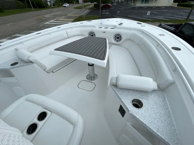 Slide: The Image of 2026 Tidewater 282 CC Adventure boat interior with seating and table, featuring cup holders. - 6