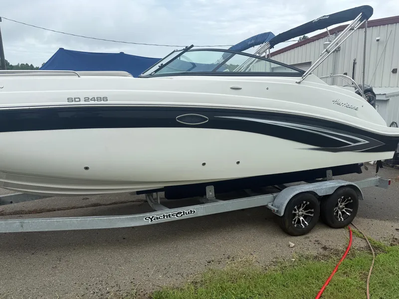 Slide: The Image of 2022 Hurricane SD 2486 boat on trailer, parked outdoors near a building. - 29