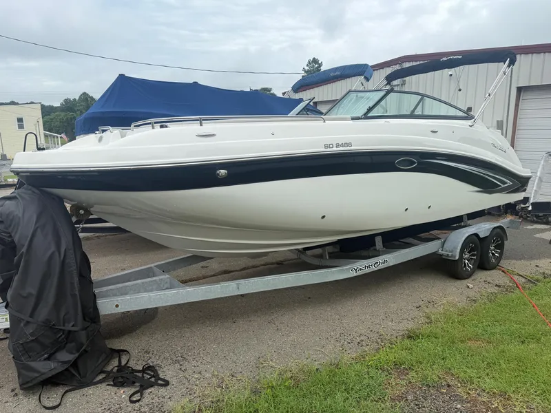 Slide: The Image of 2022 Hurricane SD 2486 boat on trailer, parked outdoors near a building. - 30