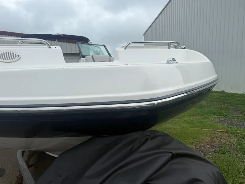 Slide: The Image of 2022 Hurricane SD 2486 boat, white hull, parked outdoors near a metal building. - 36