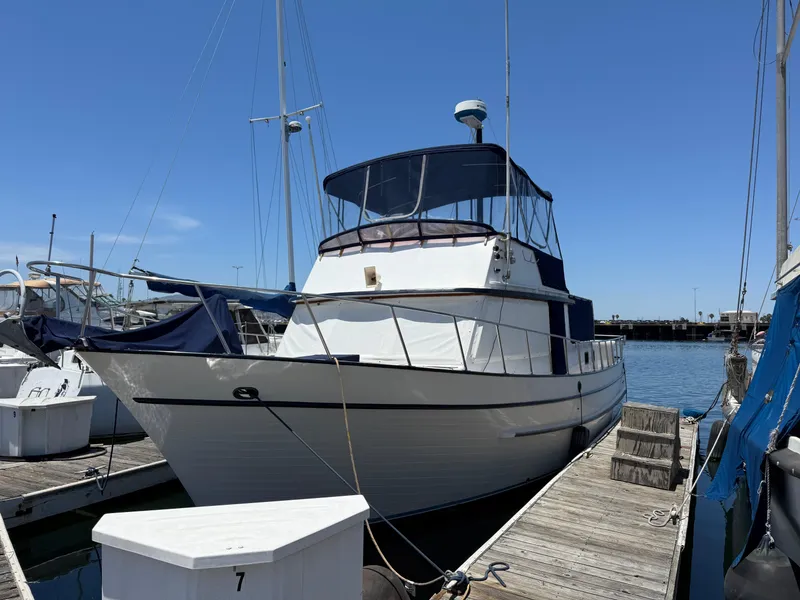 The Image of 1981 DeFever Passagemaker yacht docked at marina under clear blue sky. - 1