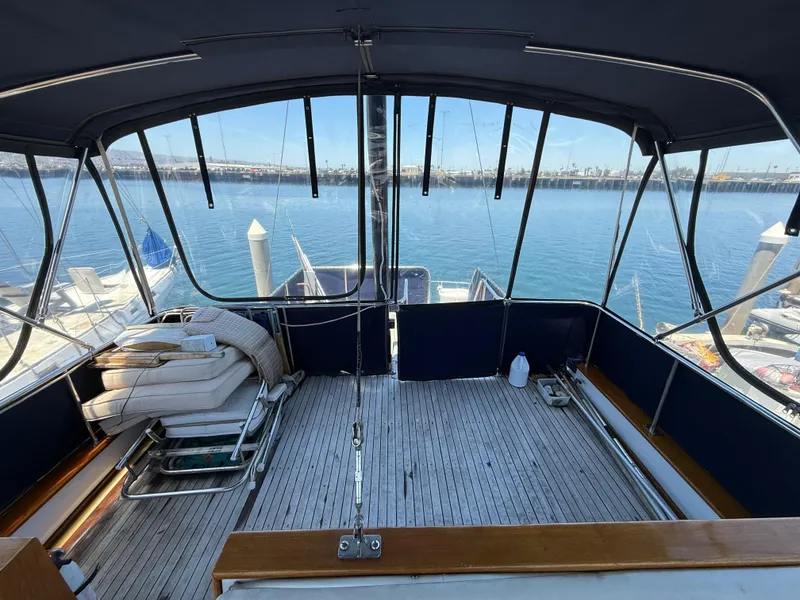 Slide: The Image of 1981 DeFever Passagemaker yacht deck with seating, overlooking marina and calm waters. - 12