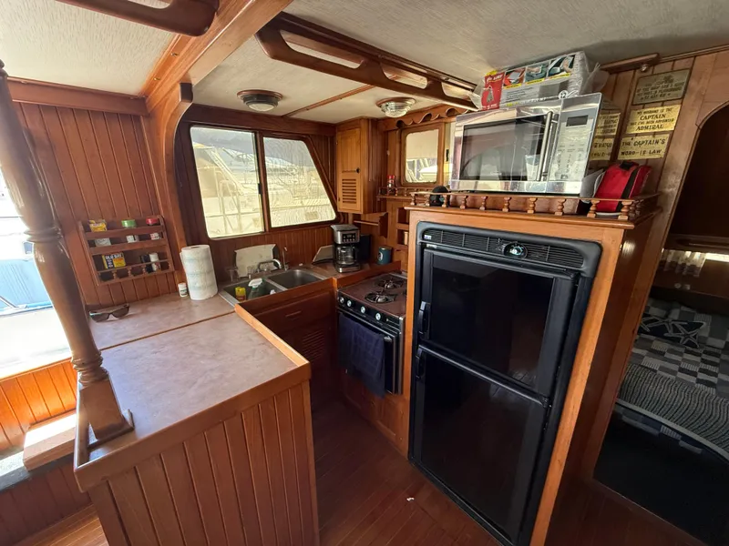Slide: The Image of 1981 DeFever Passagemaker yacht kitchen with wood cabinetry, appliances, and cozy interior. - 15
