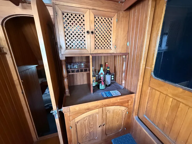 Slide: The Image of 1981 DeFever Passagemaker interior with wooden cabinetry and liquor storage. - 16