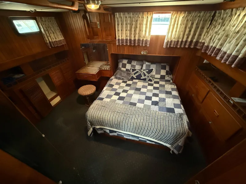 Slide: The Image of 1981 DeFever Passagemaker cabin with wood paneling, bed, and nautical decor. - 20