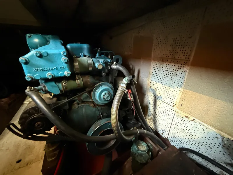 Slide: The Image of Engine of 1981 DeFever Passagemaker boat, featuring blue components and hoses. - 26