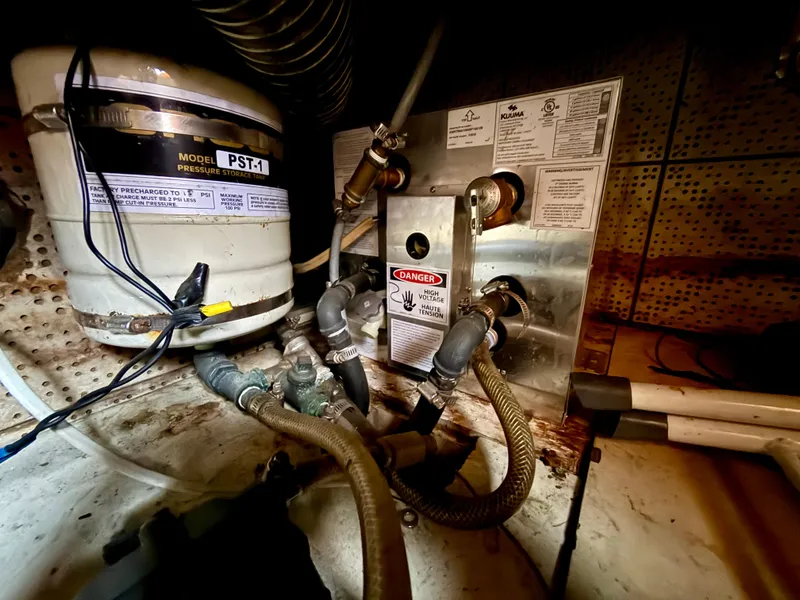 Slide: The Image of Engine room of 1981 DeFever Passagemaker with pressure storage tank and high voltage warning. - 28