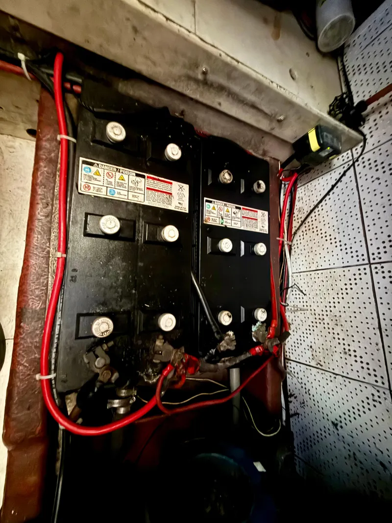 Slide: The Image of 1981 DeFever Passagemaker engine room with dual batteries and red wiring. - 29