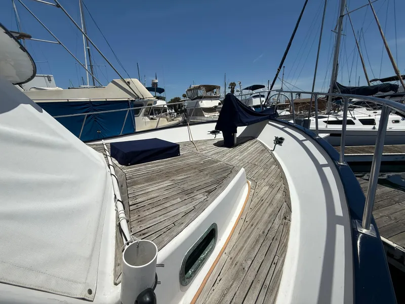 Slide: The Image of 1981 DeFever Passagemaker yacht with wooden deck, docked in a marina under clear skies. - 4