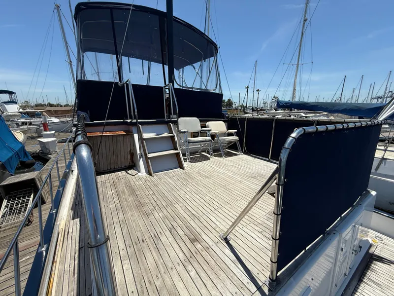 Slide: The Image of 1981 DeFever Passagemaker yacht deck with seating and canopy in marina. - 5
