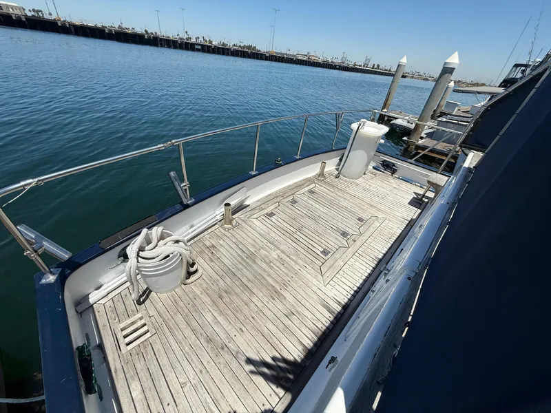 Slide: The Image of 1981 DeFever Passagemaker yacht deck with wooden flooring, docked at a marina. - 6