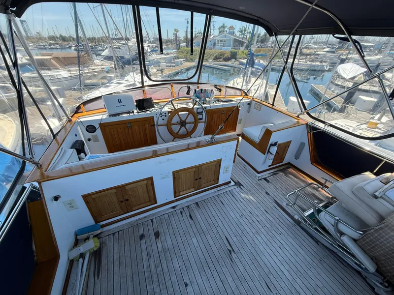 Slide: The Image of 1981 DeFever Passagemaker yacht helm with wooden wheel and marina view. - 7