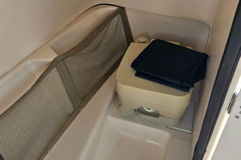 Slide: The Image of Interior of a 2012 Grady-White Freedom 205 boat with portable toilet and storage net. - 20