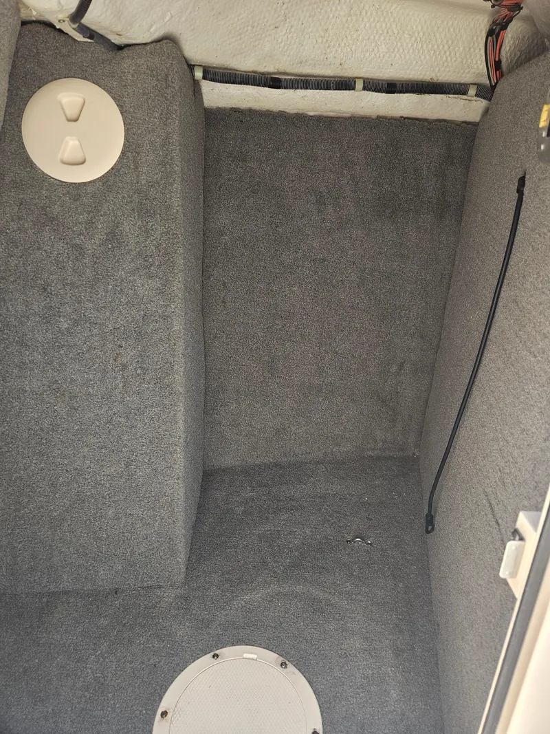 Slide: The Image of Interior cabin of 2012 Grady-White Freedom 205 boat, featuring gray carpeting. - 23