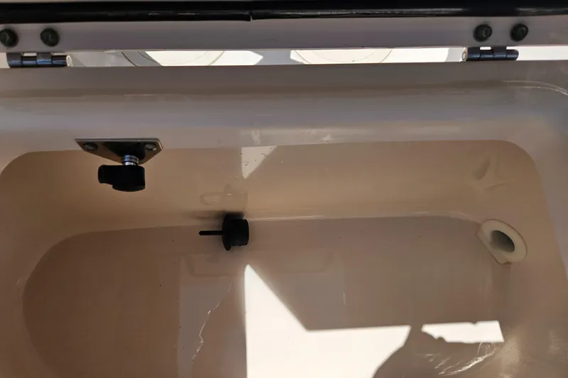 Slide: The Image of Interior compartment of 2012 Grady-White Freedom 205 boat, showing storage space and drain plug. - 27