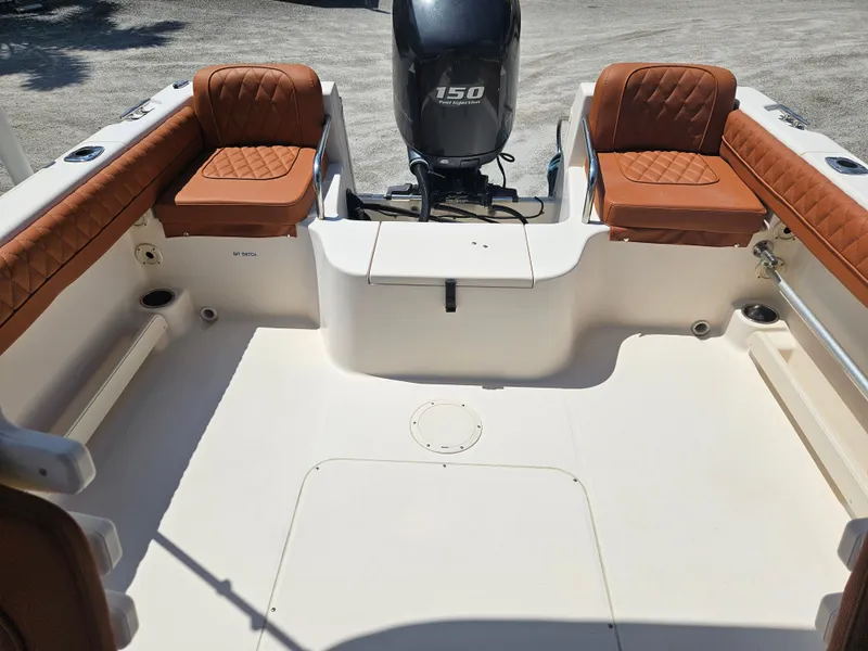 Slide: The Image of 2012 Grady-White Freedom 205 boat interior with brown seating and 150 horsepower engine. - 8