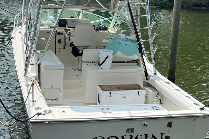 Slide: The Image of 2004 Albemarle 310 Express Fisherman boat docked, featuring fishing gear and seating. - 10