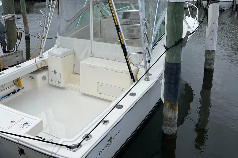 Slide: The Image of 2004 Albemarle 310 Express Fisherman boat docked, featuring spacious deck and fishing equipment. - 13