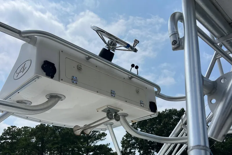 Slide: The Image of 2004 Albemarle 310 Express Fisherman boat helm, featuring stainless steel structure against a cloudy sky. - 15