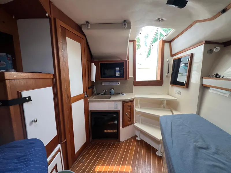 Slide: The Image of 2004 Albemarle 310 Express Fisherman cabin interior with kitchenette and wooden flooring. - 8