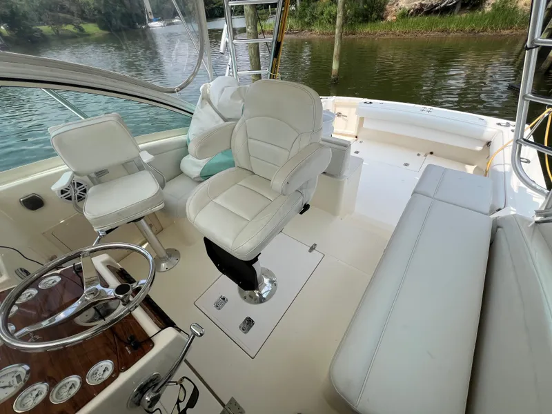 Slide: The Image of 2004 Albemarle 310 Express Fisherman boat interior with white seating and steering wheel. - 9