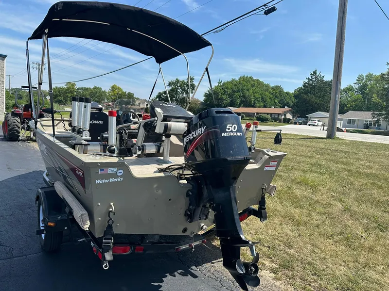 Slide: The Image of 2007 Lowe Fishing Machine FM165S with Mercury 50 engine on trailer, parked outdoors. - 4