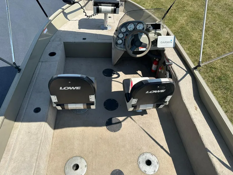 Slide: The Image of 2007 Lowe Fishing Machine FM165S interior with seats, steering wheel, and Garmin device. - 6