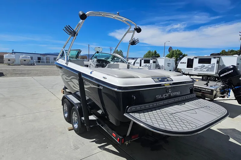 Slide: The Image of 2007 Supreme V232 boat on trailer, parked outdoors under clear blue sky. - 23