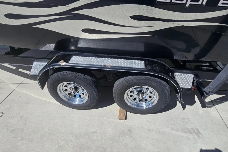 Slide: The Image of Trailer wheels of a 2007 Supreme V232 boat on a concrete surface. - 24