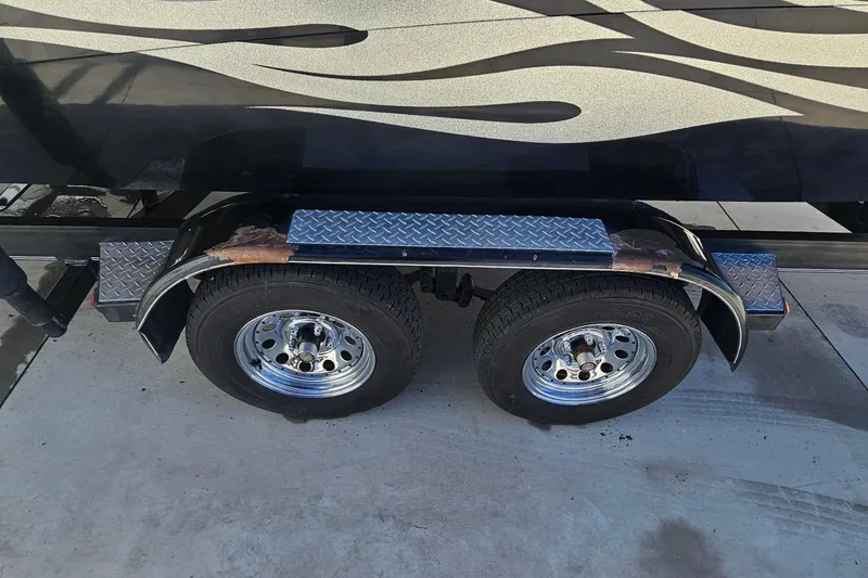 Slide: The Image of Trailer wheels and fender of a 2007 Supreme V232 boat on concrete surface. - 25
