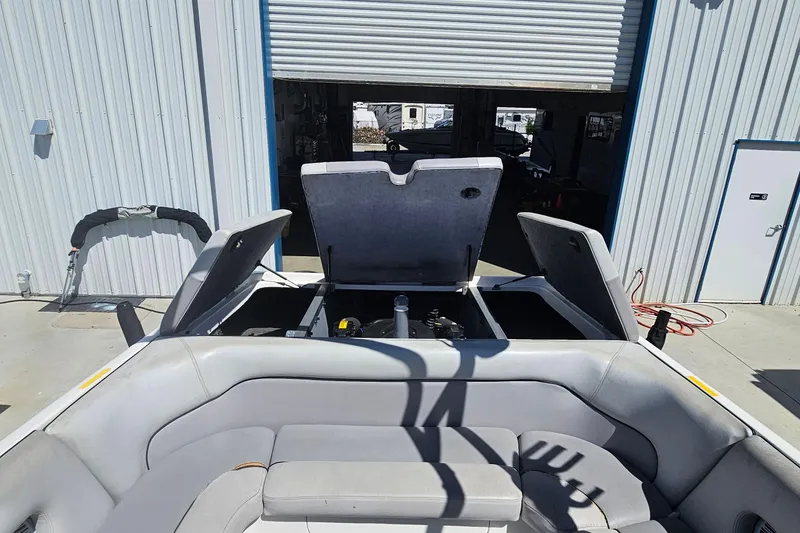 Slide: The Image of 2007 Supreme V232 boat with open engine compartment, parked outside a garage. - 41