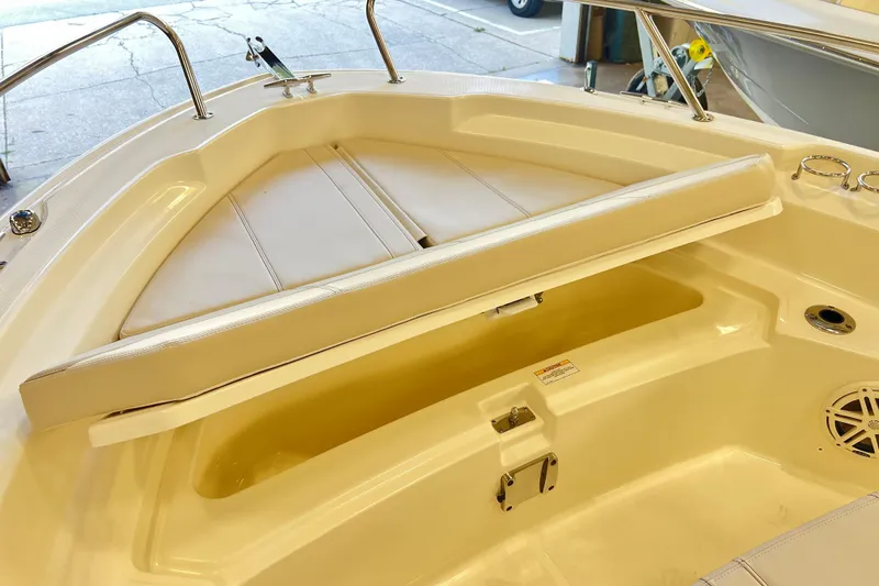 Slide: The Image of 2026 Boston Whaler 220 Dauntless boat interior with cushioned seating and storage compartment. - 12