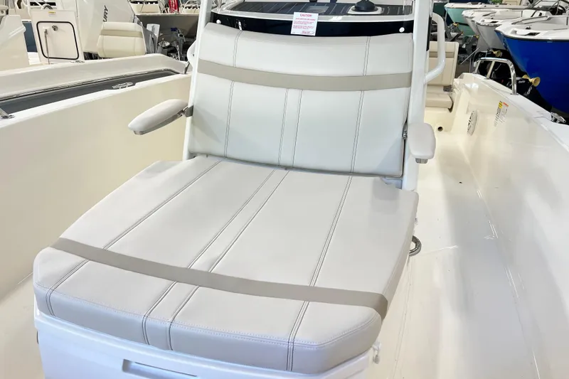 Slide: The Image of 2026 Boston Whaler 220 Dauntless boat seat, white upholstery, armrests, showroom display. - 7