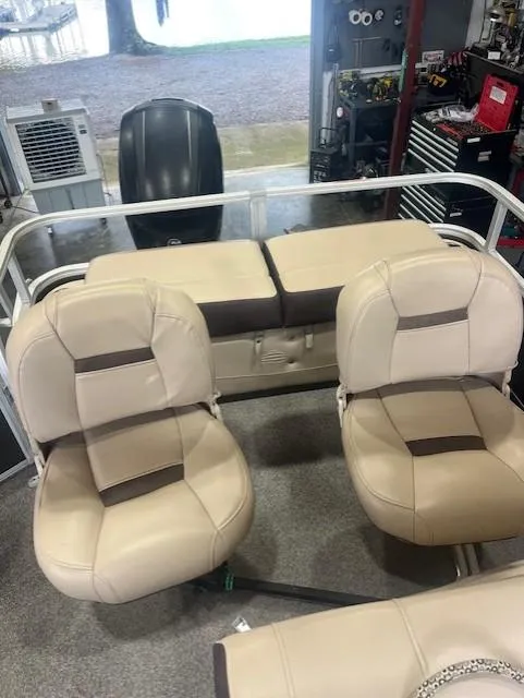 Slide: The Image of 2018 Tracker 22 DLX boat interior with beige seating and storage compartments. - 4