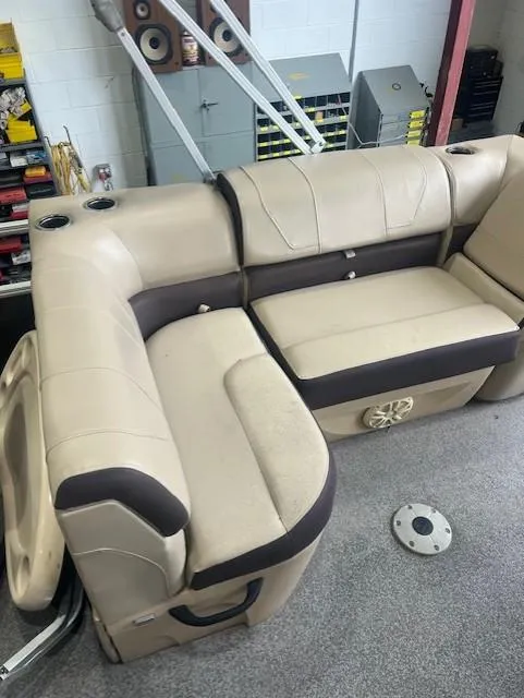 Slide: The Image of 2018 Tracker 22 DLX boat interior with beige seating and cup holders. - 6