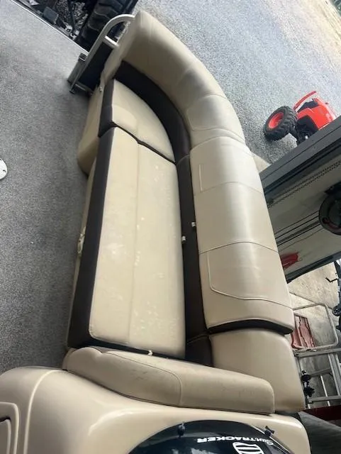 Slide: The Image of 2018 Tracker 22 DLX boat with beige seating and carpeted flooring. - 8