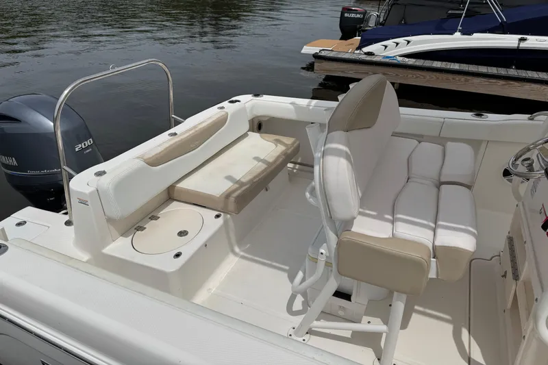 Slide: The Image of 2018 Robalo R222 Explorer boat interior with seating and Yamaha engine, docked by the water. - 10