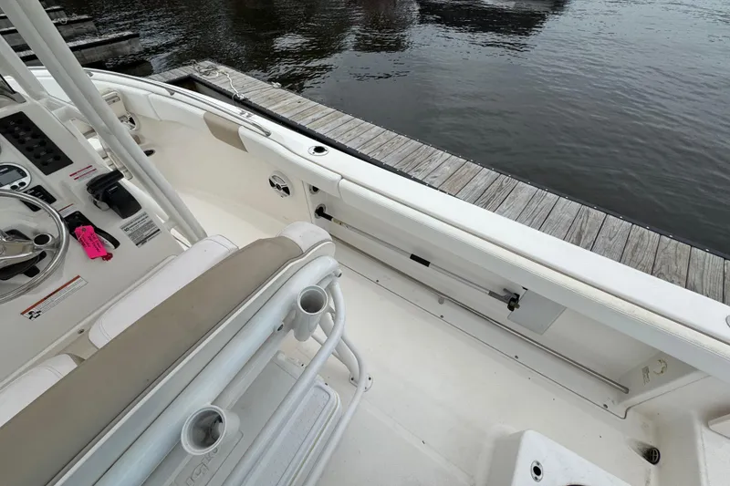 Slide: The Image of 2018 Robalo R222 Explorer boat interior near dock, featuring seating and control panel. - 12