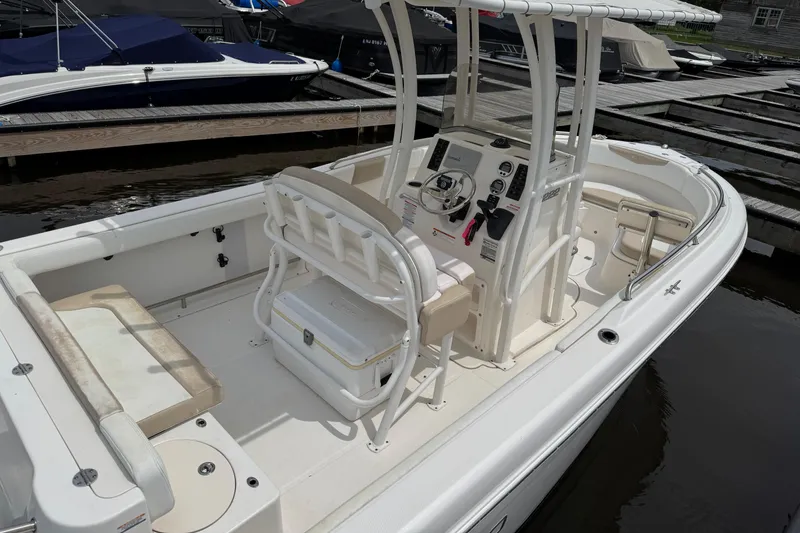 Slide: The Image of 2018 Robalo R222 Explorer boat interior at dock, featuring helm and seating area. - 5