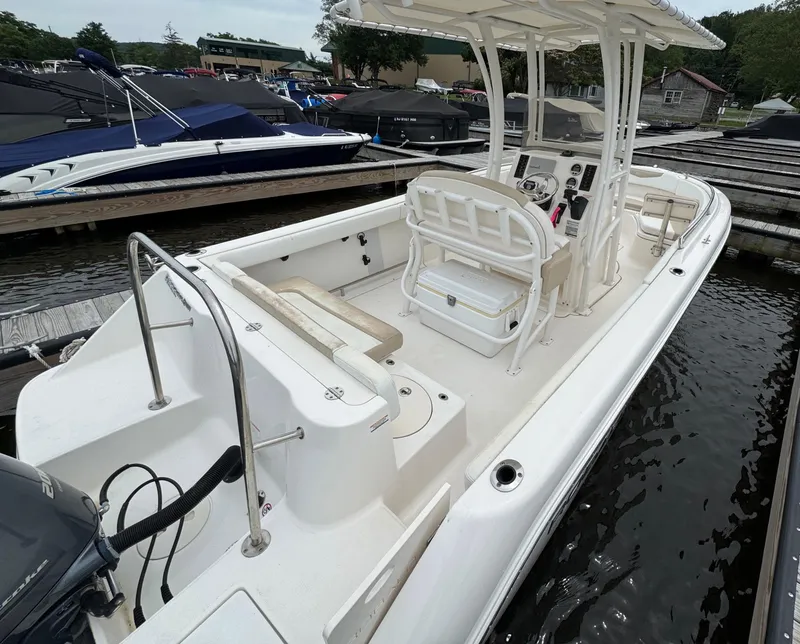 Slide: The Image of 2018 Robalo R222 Explorer boat docked, featuring spacious deck and seating. - 6