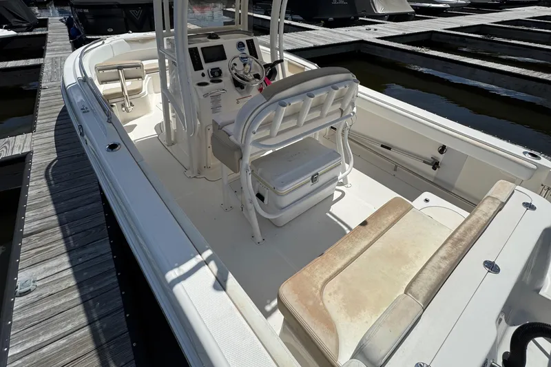 Slide: The Image of 2018 Robalo R222 Explorer boat interior at dock, featuring seating and control console. - 7