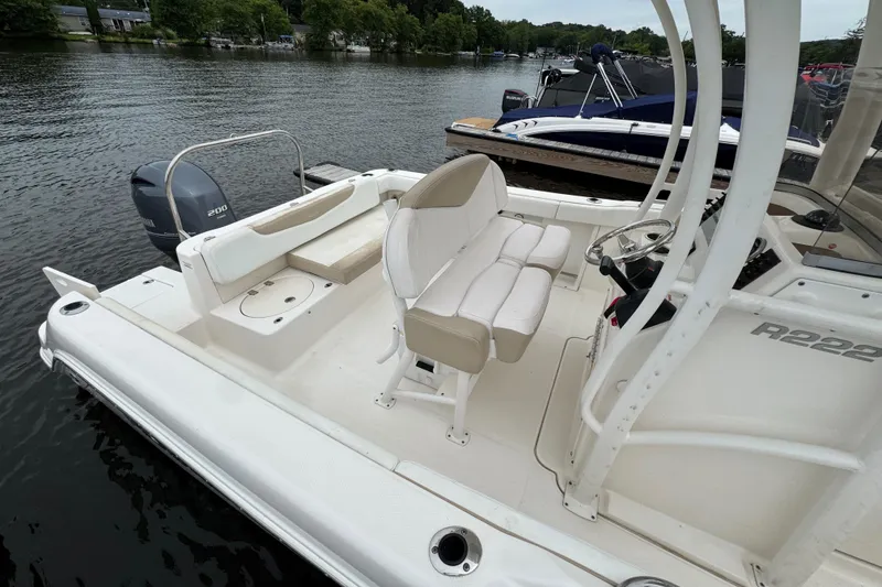 Slide: The Image of 2018 Robalo R222 Explorer boat docked, featuring seating and steering console. - 9