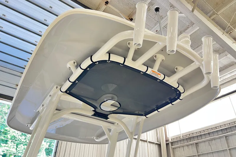Slide: The Image of 2026 Boston Whaler 250 Dauntless T-top with rod holders in a boatyard. - 8
