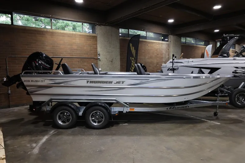 Slide: The Image of 2025 Thunder Jet 209 Rush OT boat on trailer in indoor showroom. - 1