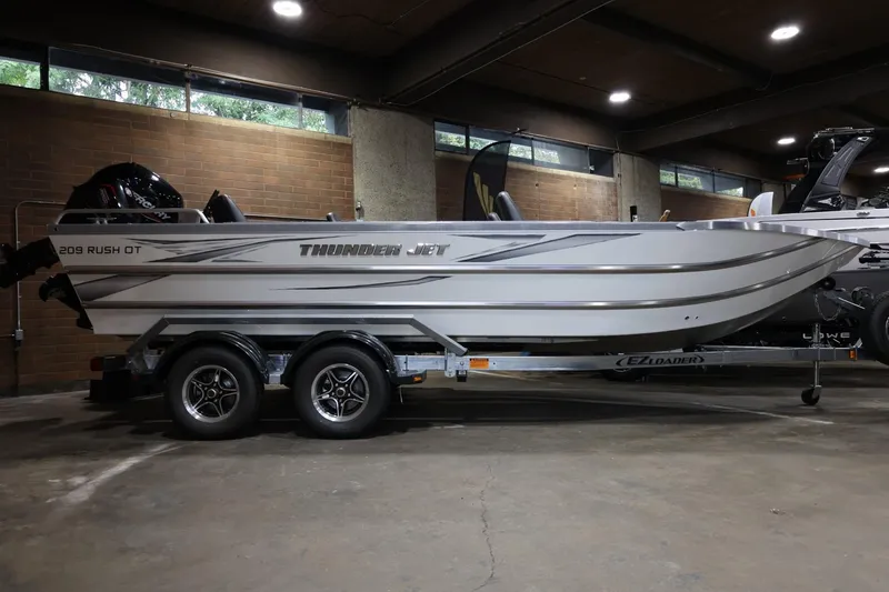 Slide: The Image of 2025 Thunder Jet 209 Rush OT boat on trailer in indoor setting. - 21